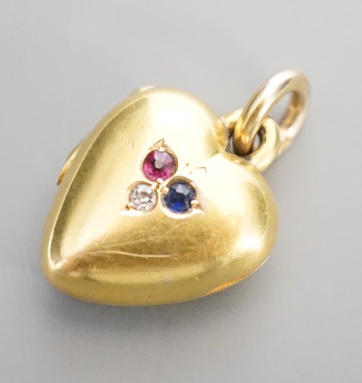 An Edwardian 15ct, sapphire, diamond and ruby set heart shaped locket, 17mm, gross weight 5.7 grams.